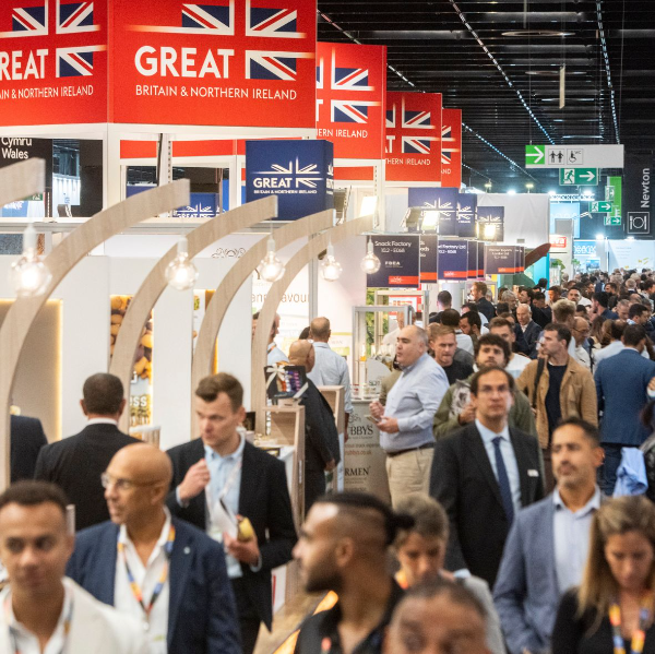Photo of Anuga trade fair showing exhibition hall with stands to left and corridor of delegates walking