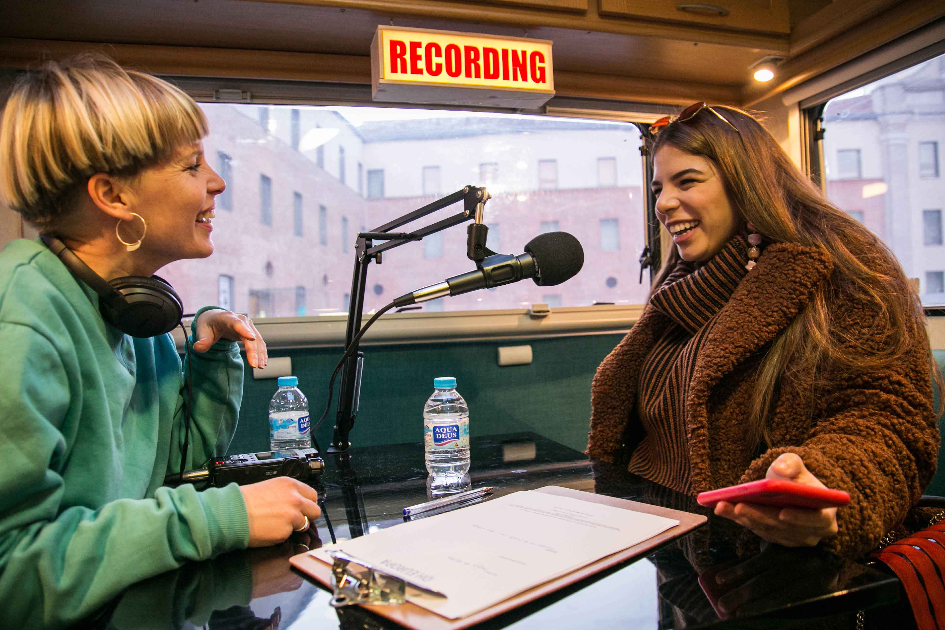 A photograph of two people in a recording studio.