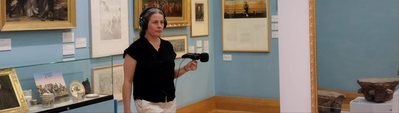 A person holding a microphone in a museum.