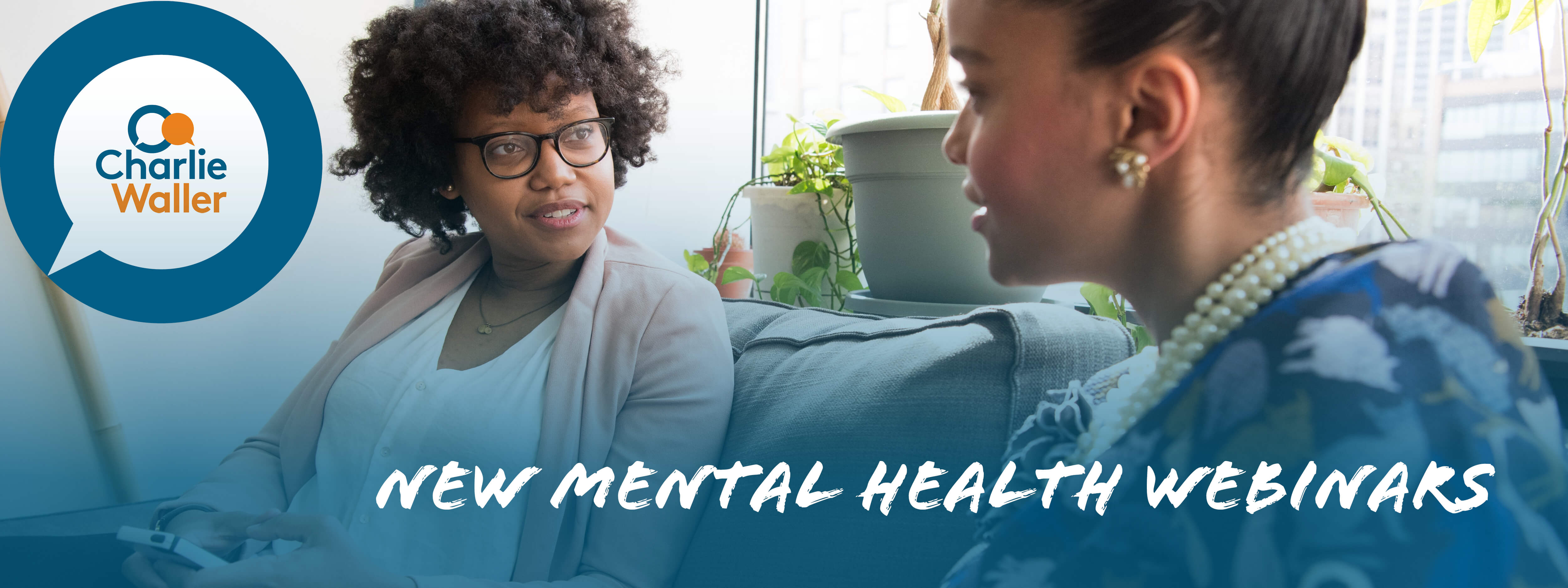 A black woman with curly black hair and glasses talking with a younger black woman sitting on a couch. There is white text which says new mental health webinars and has Charlie Waller Trust logo in the left hand corner. 