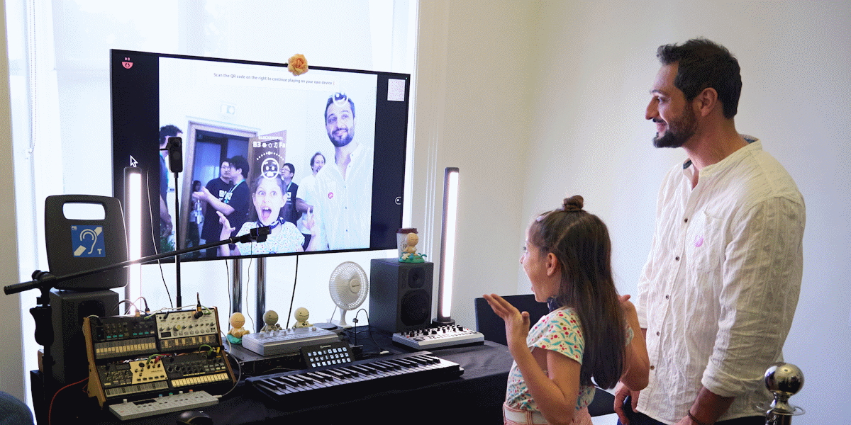 Man and child standing in front of a screen